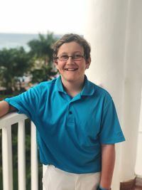 Portrait of smiling boy standing in balcony