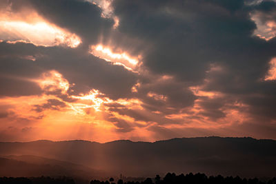 Dramatic orange sky with bleeding sun rays at dawn