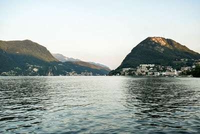 Scenic view of lake and mountains against clear sky