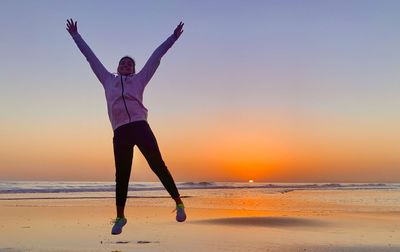 Full length of man standing at beach during sunset