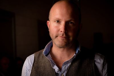 Close-up portrait of mature man standing in darkroom