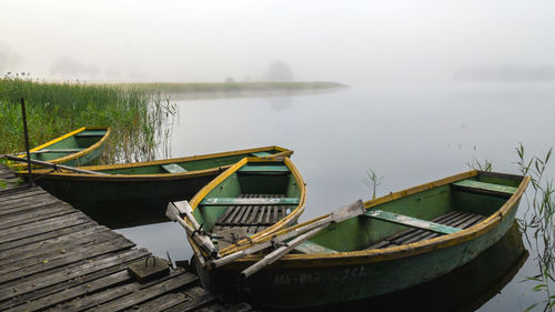 Boat moored in lake against sky