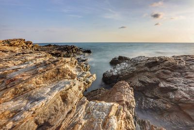 Scenic view of rock formation in sea against sky