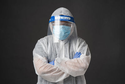 Portrait of doctor wearing mask against black background