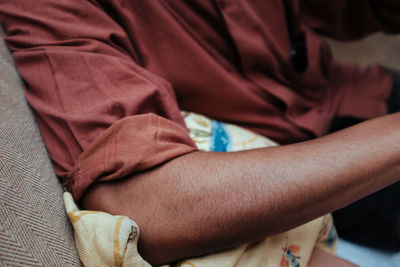 Close-up of man hand on bed