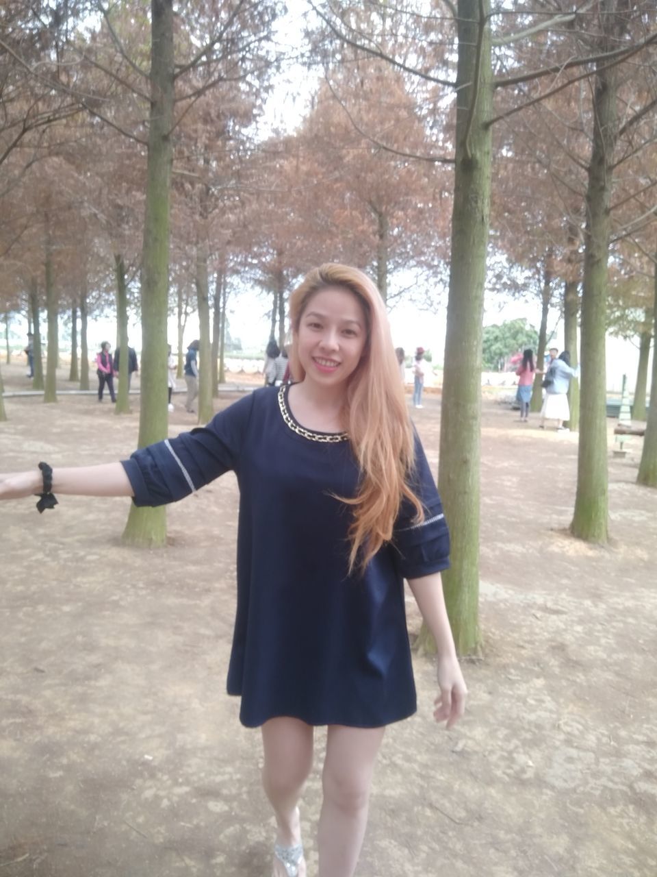 PORTRAIT OF SMILING YOUNG WOMAN IN PARK