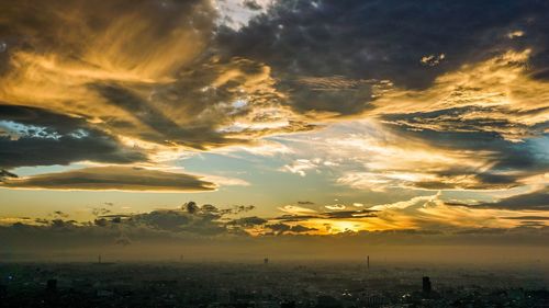 Aerial view of cityscape against dramatic sky