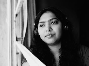 Portrait of smiling woman standing at home