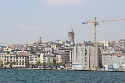 Buildings by city against sky