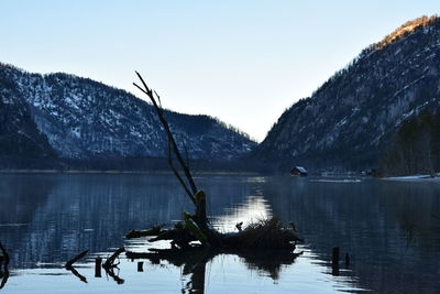 Scenic view of lake by mountains against clear sky