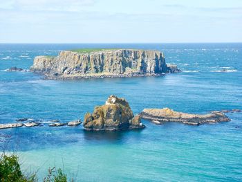 Scenic view of rocks in sea against sky