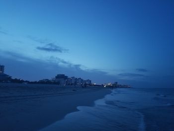Scenic view of beach against sky at dusk