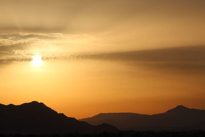 Scenic view of silhouette mountains against sky during sunset