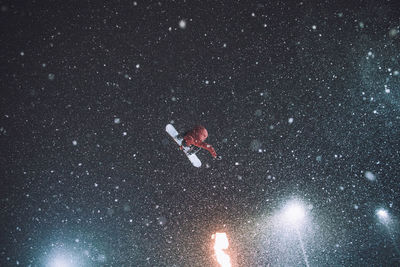 Low angle view of man snowboarding against sky during winter