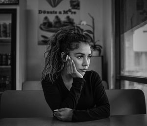 Woman looking away while sitting in cafe