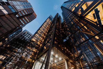 Low angle view of illuminated buildings against sky in city