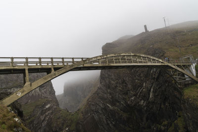 Bridge over mountains against sky