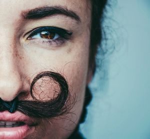 Cropped image of woman with artificial mustache