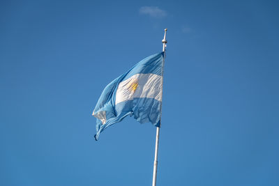 Low angle view of flag against clear blue sky