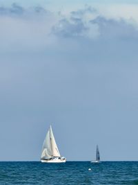 Sailboat sailing in sea against sky