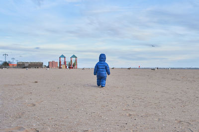 Cute toddler walking away on the beach