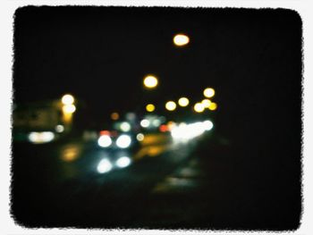 Road passing through illuminated city at night