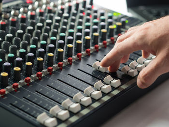 Cropped hand of man mixing music in recording studio