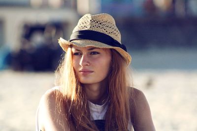 Close-up of thoughtful woman wearing hat looking away