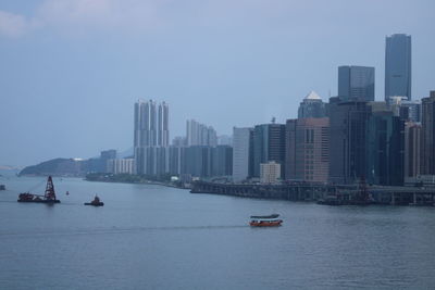 Scenic view of bay in city against sky