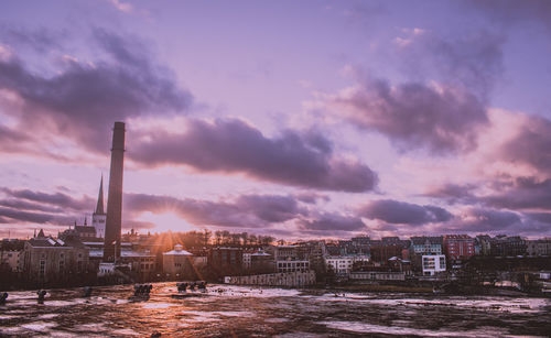 Buildings in city against sky at sunset