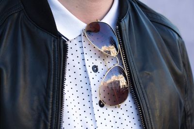 Midsection of man wearing leather jacket and sunglasses while standing outdoors