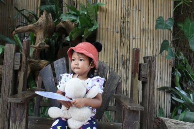 Close-up of girl holding toy while sitting outdoors
