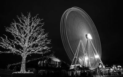 Low angle view of illuminated ferris wheel against sky at night