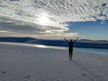 Full length of man standing in sea against sky during sunset