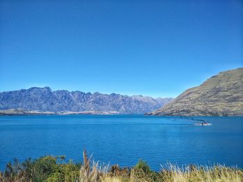 Scenic view of lake against clear blue sky