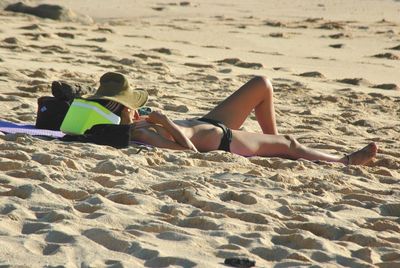 Woman lying down on sand at beach
