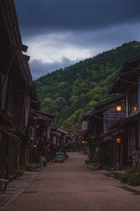 Street amidst houses and buildings against sky