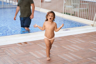 Cute girl running near poolside