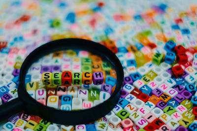 Close-up of toy blocks on magnifying glass