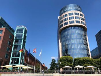 Low angle view of modern buildings against blue sky