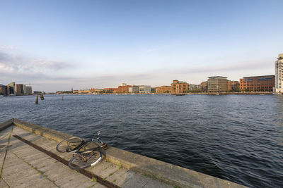 Scenic view of lake against sky in city