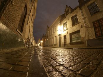 Street amidst buildings against sky at night