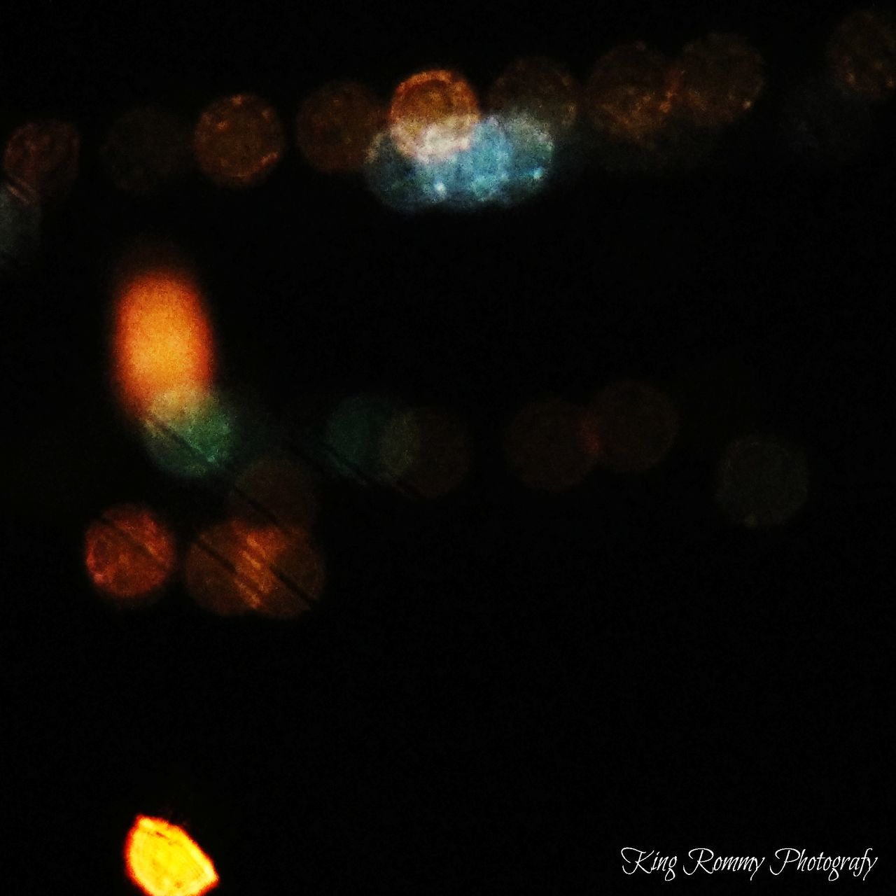 DEFOCUSED IMAGE OF LIGHTS AGAINST BLACK BACKGROUND