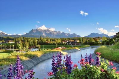 Scenic view of lake and mountains against blue sky