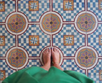 Low section of woman standing on tiled floor