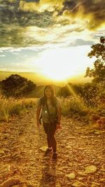 Full length of teenage girl on field against sky during sunset