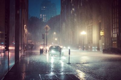 Cars on road in city at night during rainy season