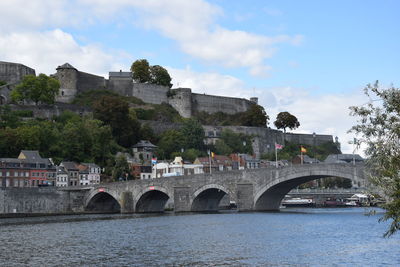 Arch bridge over river against sky