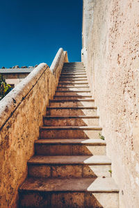 Low angle view of staircase against clear blue sky