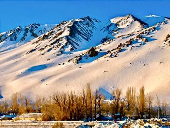 Panoramic view of snow covered mountains against sky